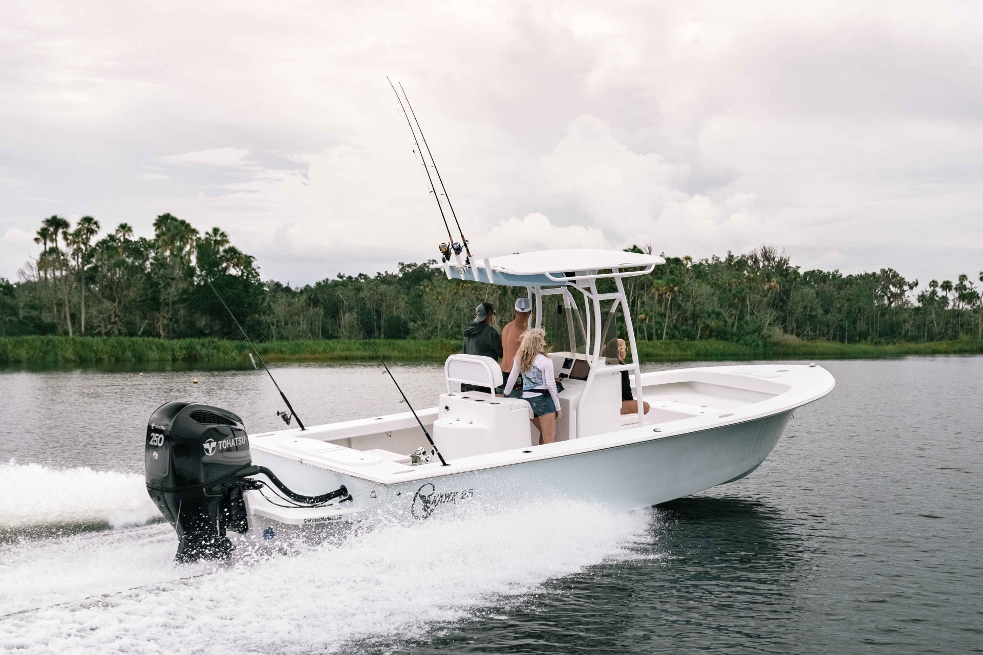 Tohatsu outboards anchored on the white boat sailing in a wide water surface