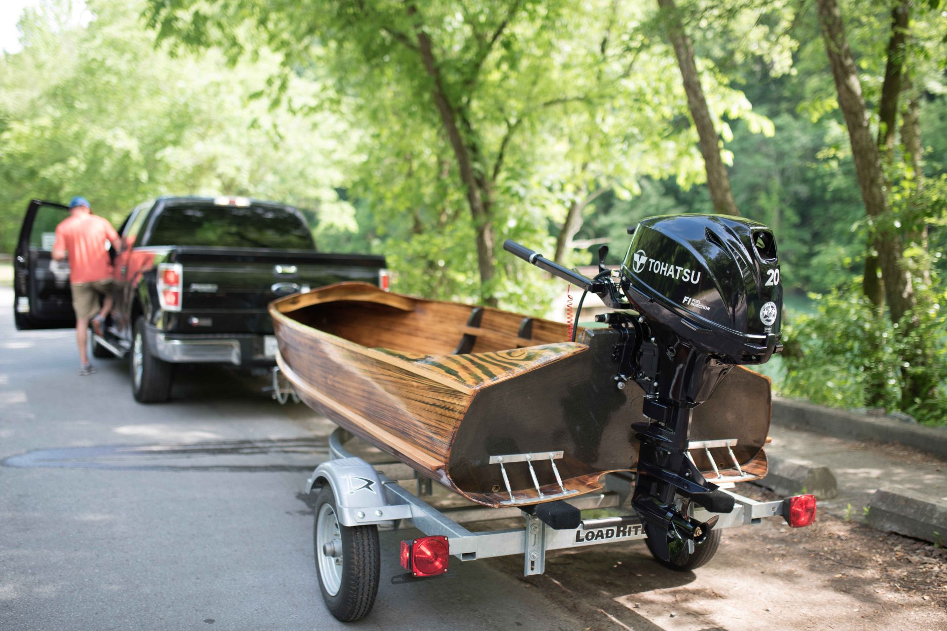 Tohatsu outboards anchored in a wooden style boat on a boat trailer